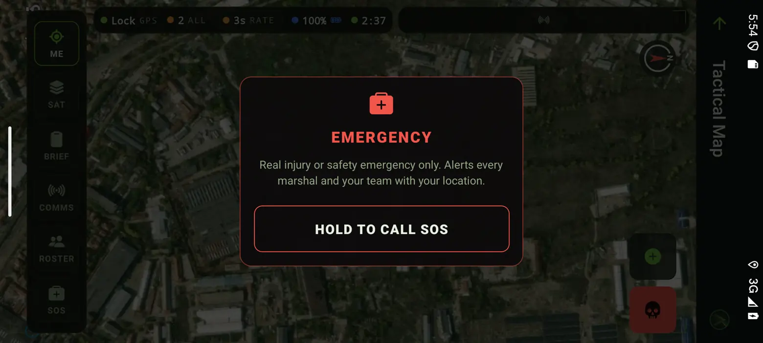 The map in landscape with the SOS dialog open: EMERGENCY - real injury or safety emergency only, alerts every marshal and your team with your location - and a hold-to-call button.
